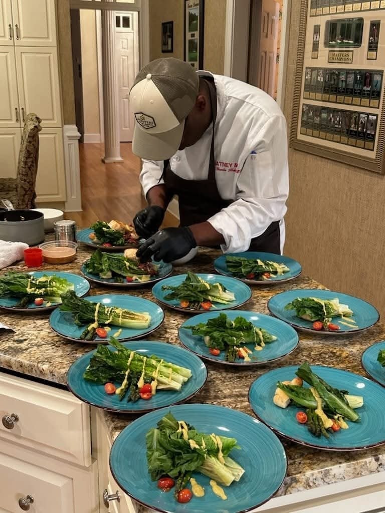 Chef Charlie Hatney plating salad dishes in kitchen